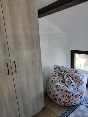 a bedroom with a bed next to a wooden cabinet at Apartment 7 in Tsarevo
