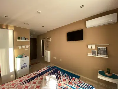 a bedroom with a bed and a tv on the wall at PARADISO 'В' 106 Private Cozy Studio NESSEBAR in Nesebar