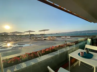 a balcony with a view of a pool and tables and umbrellas at PARADISO 'В' 106 Private Cozy Studio NESSEBAR in Nesebar