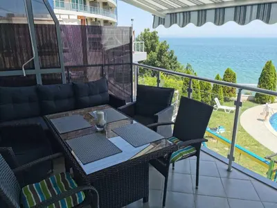 a balcony with a table and chairs and the ocean at Silver A 27 in Byala