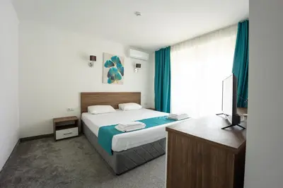 a bedroom with a bed and a television in it at Hotel Zonya in Sunny Beach