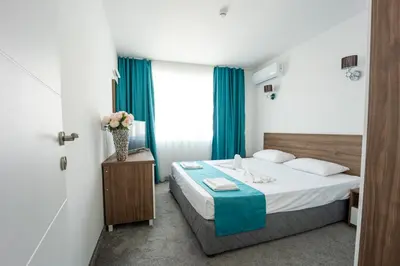 a hotel room with a bed and a vase of flowers at Hotel Zonya in Sunny Beach