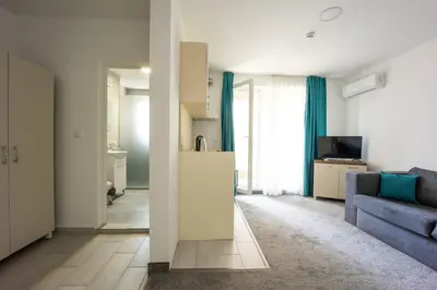 a living room with a blue couch and a kitchen at Hotel Zonya in Sunny Beach