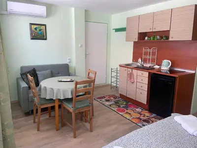 a kitchen and dining room with a table and chairs at Къща за гости ЕЛЕНИ in Sozopol