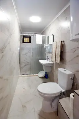 a white bathroom with a toilet and a shower at Deluxe 2 Studios City Center in Burgas City