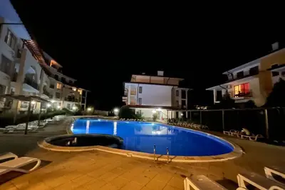 an empty swimming pool at night with buildings at Apartment Doris in Sunny Beach