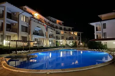 a swimming pool in front of some buildings at night at Apartment Doris in Sunny Beach