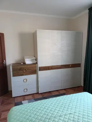 a bedroom with a dresser and a large white cabinet at Sun Wave EXCLUSIVE in Sveti Vlas