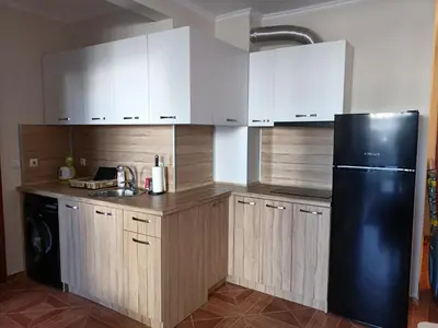 a kitchen with white cabinets and a black refrigerator at Sun Wave EXCLUSIVE in Sveti Vlas