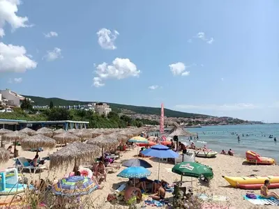 a beach with many people and umbrellas and the water at Sun Wave EXCLUSIVE in Sveti Vlas