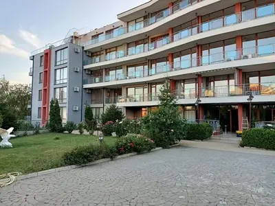 a large apartment building with a garden in front of it at Sun Wave EXCLUSIVE in Sveti Vlas