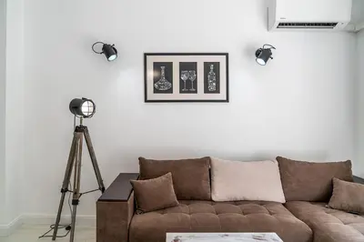 a living room with a brown couch and a tripod at Jazz & Wine - Luxury apARTment By The Sea & Parking & HBO & Netflix in Varna City