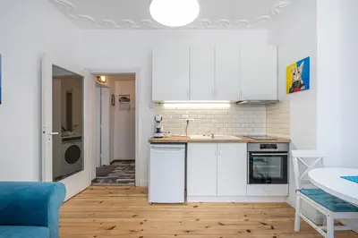 a kitchen with white cabinets and a wooden floor at Jazz & Wine - Luxury apARTment By The Sea & Parking & HBO & Netflix in Varna City