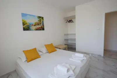 a white couch with two orange pillows in a room at Luxury First Line apartment with pool by the sea in Nesebar