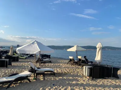a group of chairs and umbrellas on a beach at AFRODITA I 112 Private Cozy Studio Sunny Beach in Sunny Beach