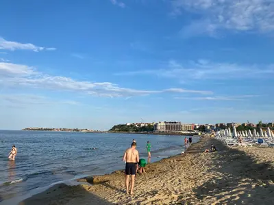 a man standing on a beach near the water at AFRODITA I 112 Private Cozy Studio Sunny Beach in Sunny Beach