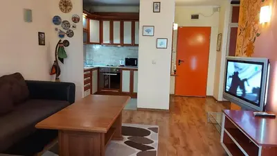 a living room with a couch and a flat screen tv at Апартамент Златна дюна-Фешева in Nesebar