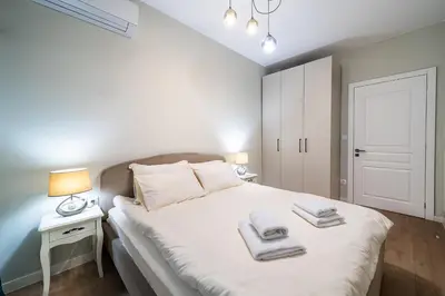 a bedroom with a white bed with towels on it at Smart Central Apartment in Varna City