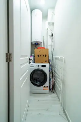 a laundry room with a washing machine in a hallway at Smart Central Apartment in Varna City