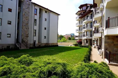 a large grassy yard between two buildings at Byala Vista Beach Apartments D - Бяла Виста Бийч Апартментс Д in Byala