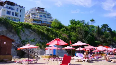 a bunch of umbrellas and chairs on a beach at Byala Vista Beach Apartments D - Бяла Виста Бийч Апартментс Д in Byala