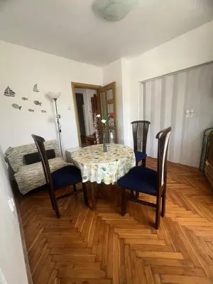 a dining room with a table and chairs and a room at Апартамент Иванови in Pomorie