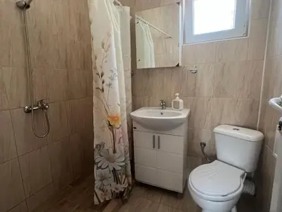 a bathroom with a toilet and a sink and a mirror at Апартамент Иванови in Pomorie