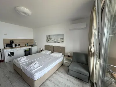 a small bedroom with a bed and a chair at Апартаменти за гости 