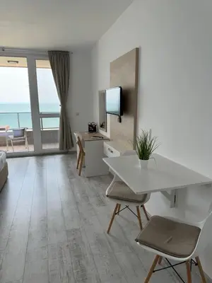 a living room with a table and chairs and a television at Апартаменти за гости 