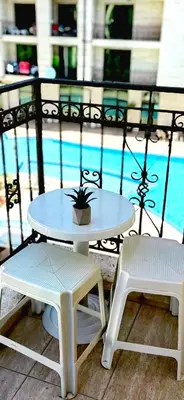 a table and two chairs next to a pool at Family Apartments Amadeus lux in Sunny Beach