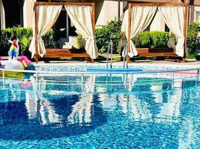 a swimming pool with a reflection in the water at Апартамент Свети Влас in Sveti Vlas