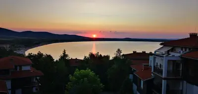 a sunset over a river in a city with buildings at Sunrise - Apartment 41,Santa Marina, Sozopol in Sozopol