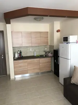 a kitchen with wooden cabinets and a white refrigerator at Rich-2 SP apartments in Ravda