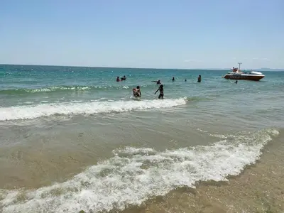 a group of people in the ocean with a boat at Rich-2 SP apartments in Ravda