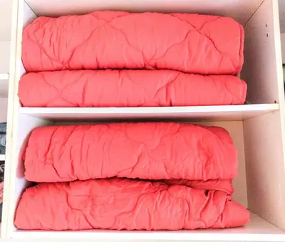four red pillows sitting on shelves in a closet at Summer Downtown - Compact Basic Flat - 1st floor in Burgas City