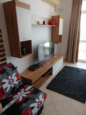a living room with a flat screen tv on a wooden stand at Apolon 2 in Sozopol