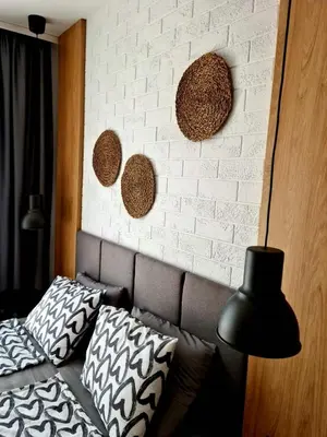 a bedroom with a couch and a white brick wall at Studio Greenn Life Beach Resort in Sozopol