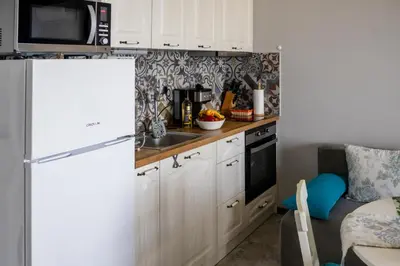 a kitchen with white cabinets and a white refrigerator at A-33-Sea View Studio Apartment Sarafovo in Burgas City
