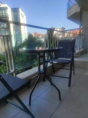 a glass table and two chairs on a balcony at Apartament in sun waves in Burgas City