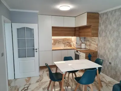 a kitchen with a white table and blue chairs at Sarafovo Sea Star in Burgas City
