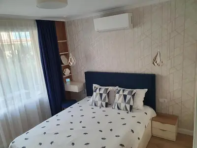 a small bedroom with a bed with a blue headboard at Sarafovo Sea Star in Burgas City