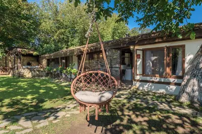 a swing hanging from a tree in front of a house at Villa Viara in Pchelnik