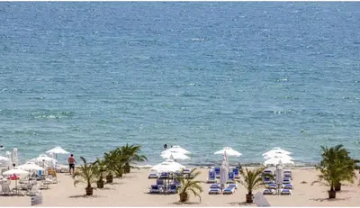 a beach with chairs and umbrellas and the ocean at A-19 Sea View Studio-Apartmen Sarafovo in Burgas City