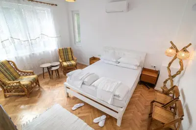 a bedroom with a white bed and a table and chairs at Апартамент BOHO CHIC Free parking in Varna City