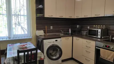 a kitchen with a washing machine and a microwave at Apartment Lazur Karlovo 8 street free parking in Burgas City