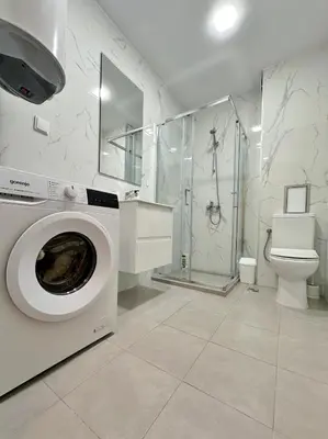 a bathroom with a washing machine and a toilet at Central Flat & Free Parking in Varna City