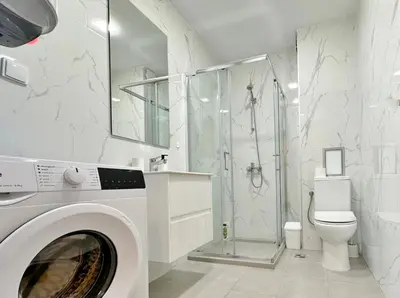 a white bathroom with a washing machine in it at Central Flat & Free Parking in Varna City