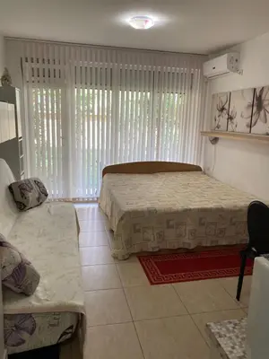 a bedroom with two beds and a couch at Уютная квартира - студия в Старом Поморие, Болгария in Pomorie