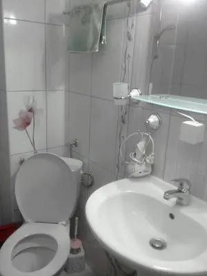 a bathroom with a white toilet and a sink at Уютная квартира - студия в Старом Поморие, Болгария in Pomorie
