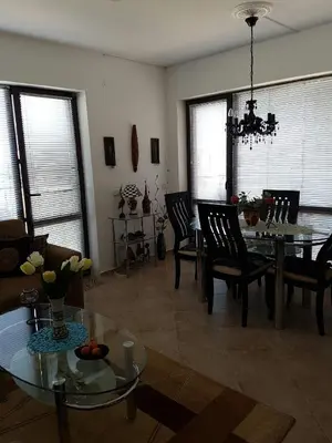a living room with a table and chairs and a chandelier at Ravda Sun Sea Ressort 2 in Ravda